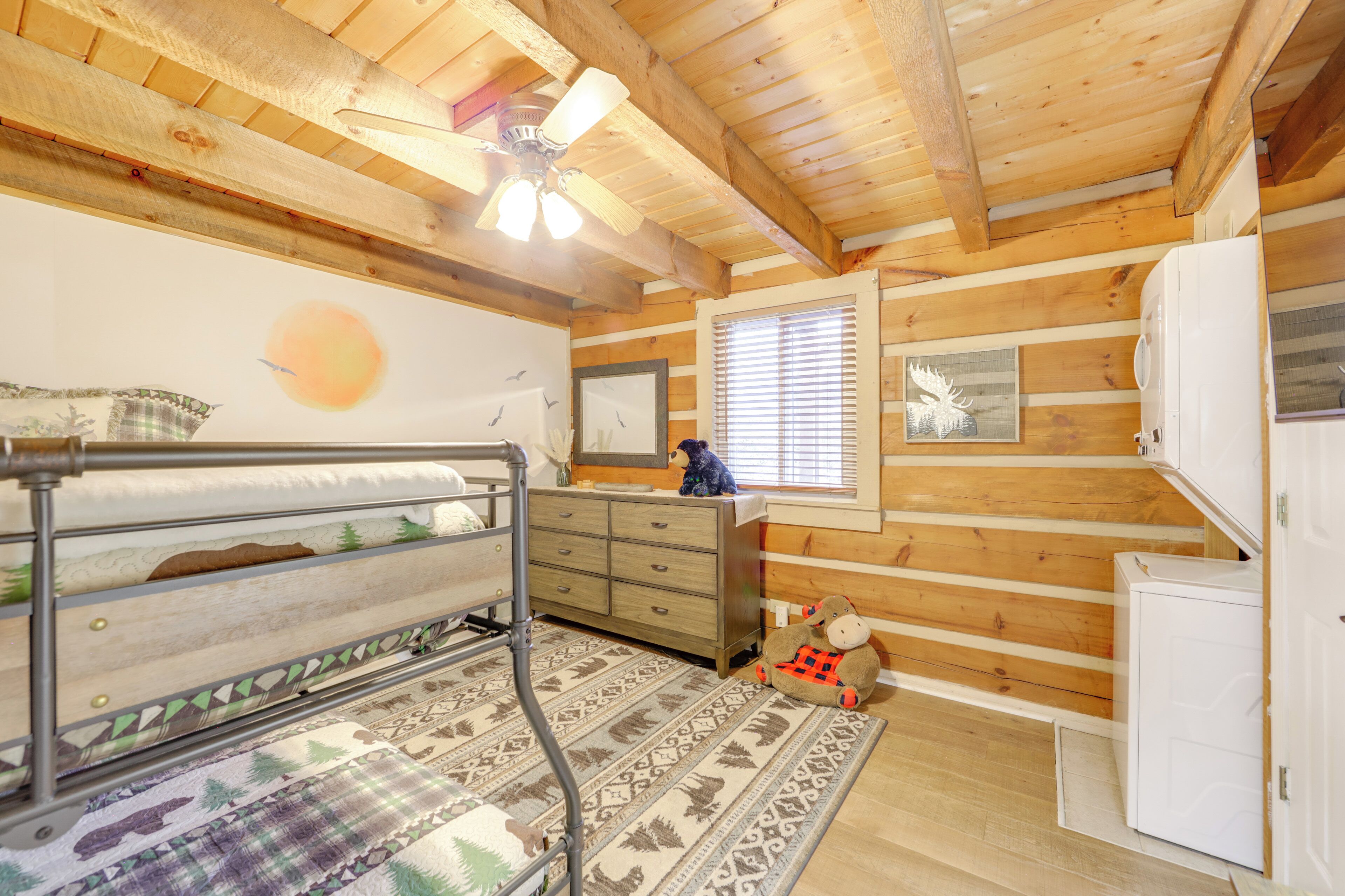 L'intérieur d'une cabine comprend un lit superposé, des murs en bois, un ventilateur de plafond, une fenêtre avec des stores et un petit réfrigérateur.