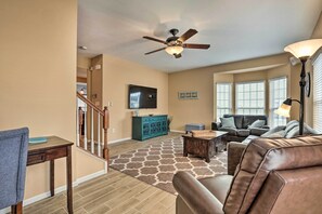 Relax in this stylish living area with a leather sofa, coffee table, and mounted TV.