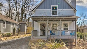 A two-story house with a front porch, a small attached garage, and a visible chimney. - Downtown Brevard Retreat With Fire Pit & Deck! (Brevard)