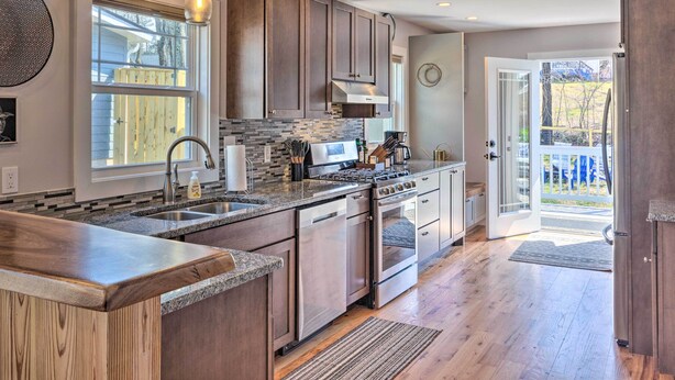 A modern kitchen with granite countertops, stainless steel appliances, and a large island. - Downtown Brevard Retreat With Fire Pit & Deck! (Brevard)
