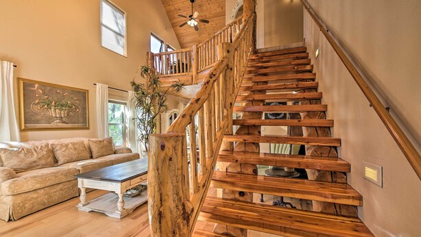 A wooden staircase with a railing, a beige sofa, a coffee table, and a painting on the wall. - < 2 Mi to Hikes & Shops: Show Low Home w/ Deck (Show Low)