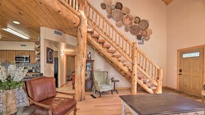 A spacious living area with a wooden staircase, leather furniture, and a dining table. - < 2 Mi to Hikes & Shops: Show Low Home w/ Deck (Show Low)