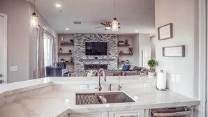 A modern kitchen with a large island, built-in appliances, and a stone fireplace. - Vistas Bonitas Home w/ Patio: 7 Mi to Snowbowl! (Flagstaff)