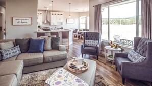 A modern living room with a sofa, armchairs, a coffee table, and a view of the kitchen and dining area. - Vistas Bonitas Home w/ Patio: 7 Mi to Snowbowl! (Flagstaff)