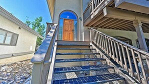 A multi-story building with a central staircase leading to a wooden door. - Mountain Home With Decks, Walk to Gondola (Steamboat Springs)