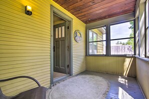 A covered porch with a wooden ceiling, a yellow exterior wall, and a door leading inside. - Quaint Stockton Escape Near Community Park! (Stockton)