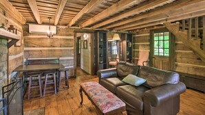 Interior rústico con una mesa de comedor de madera, un sofá de cuero y un banco.