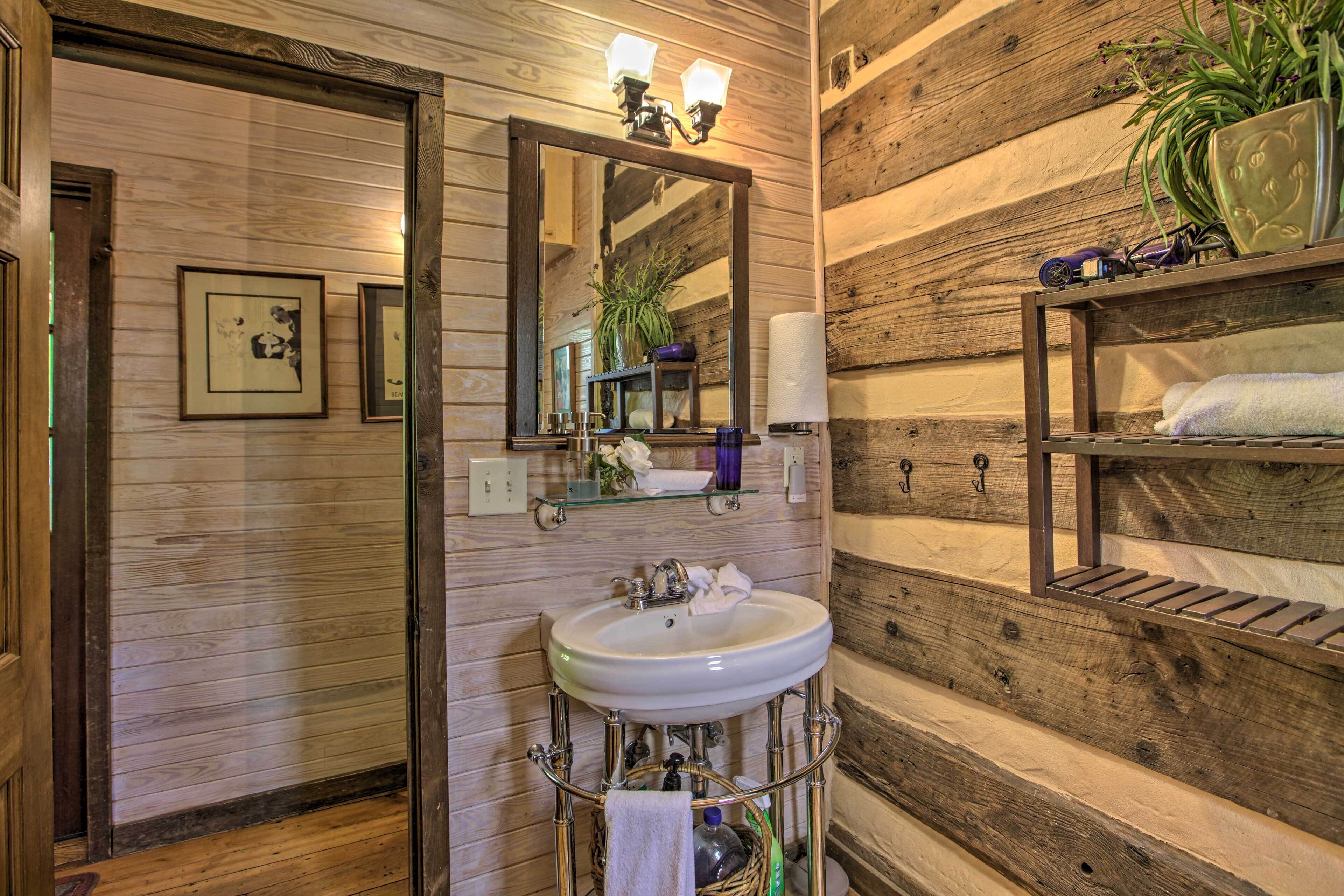 Une salle de bain avec un mur en bois, un lavabo blanc et un miroir.