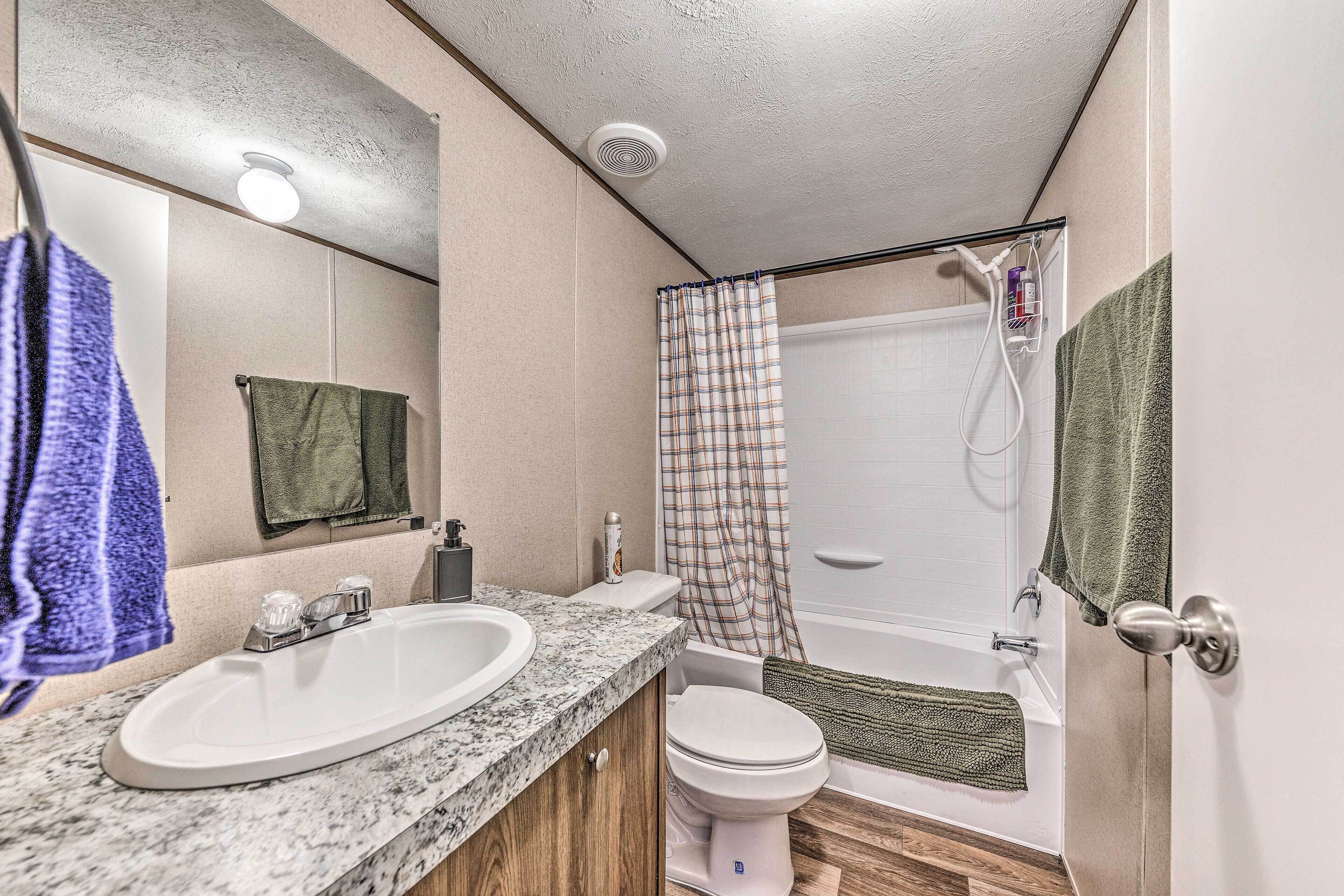 A bathroom with a sink, toilet, and shower.