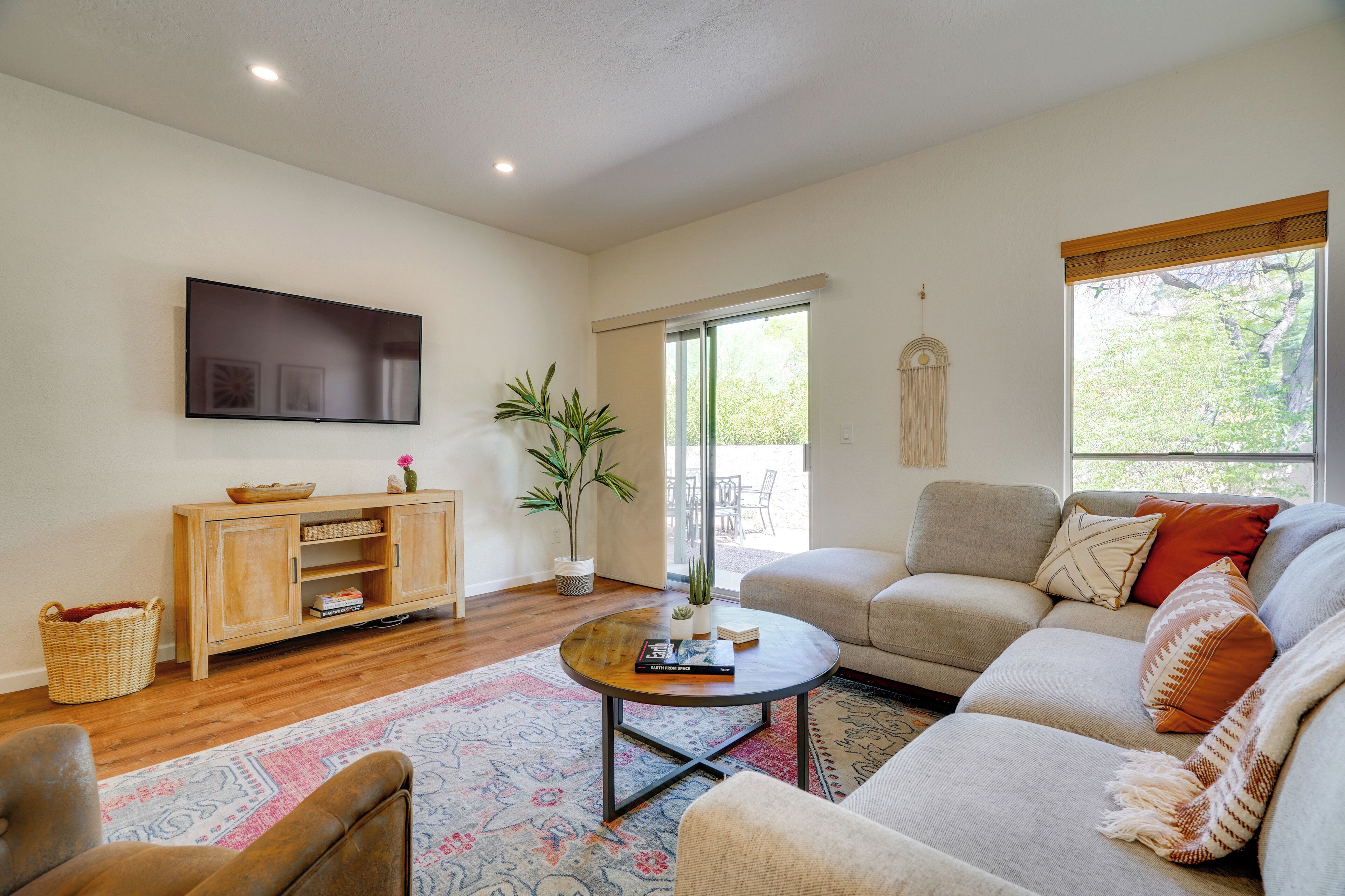 A living room with a sofa, a coffee table, a television, and a wooden cabinet.
