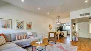 Un salon comprenant un canapé, un fauteuil, une table basse et des œuvres d’art accrochées au mur.