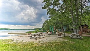 A lakeside park with picnic tables, a playground, and a cabin. - Riverview Big Bass Lake Poconos Retreat (Gouldsboro)