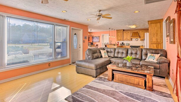 A spacious living room with a sectional sofa, a coffee table, and a ceiling fan. - Prince George Getaway Near Historic Sites! (Prince George)