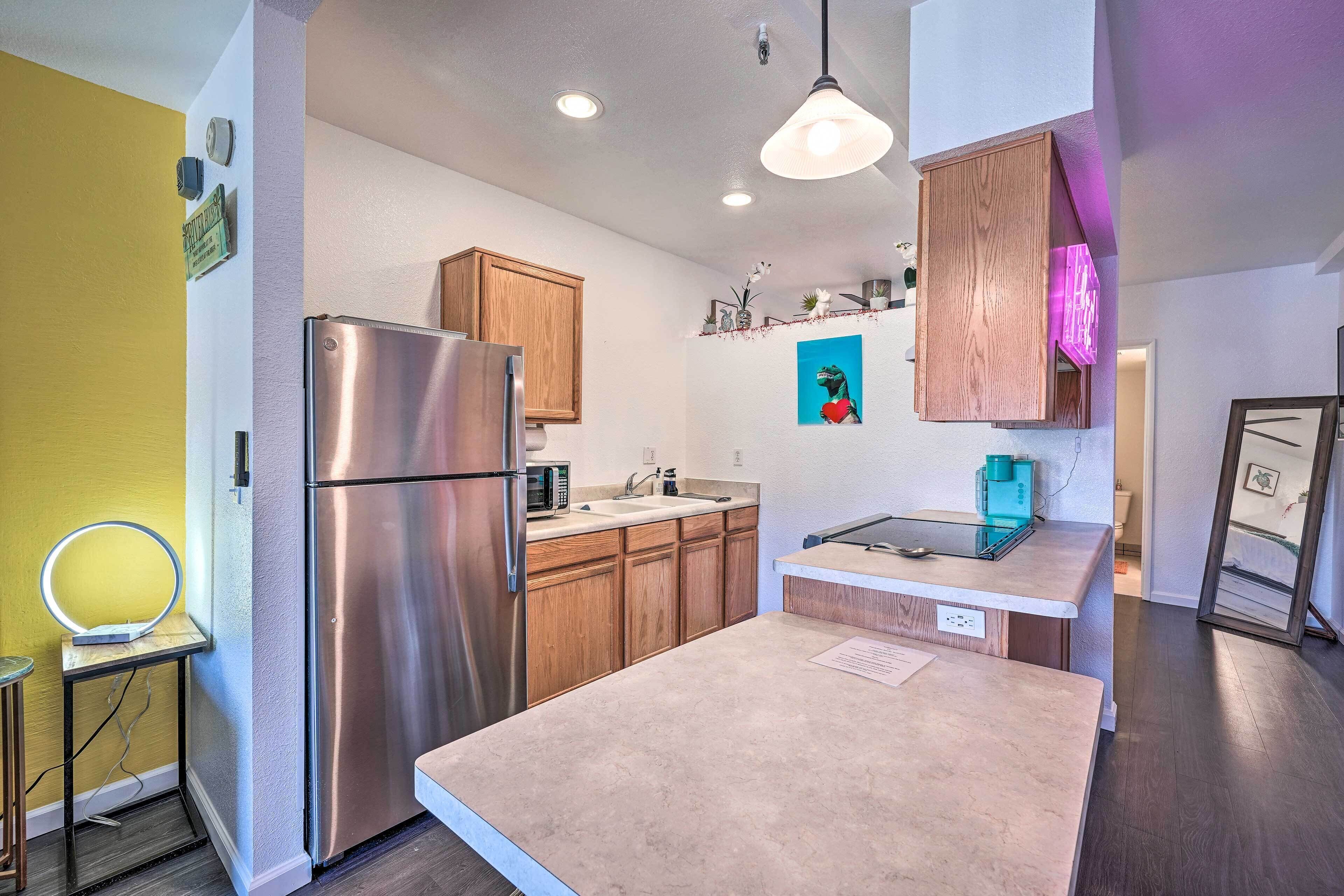 A modern kitchen with stainless steel appliances, wooden cabinets, and a small island.