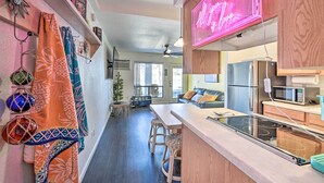 A modern kitchen with a bar area, wooden cabinets, and a neon sign. - Parker Studio w/ Patio & Direct River Access! (Parker)