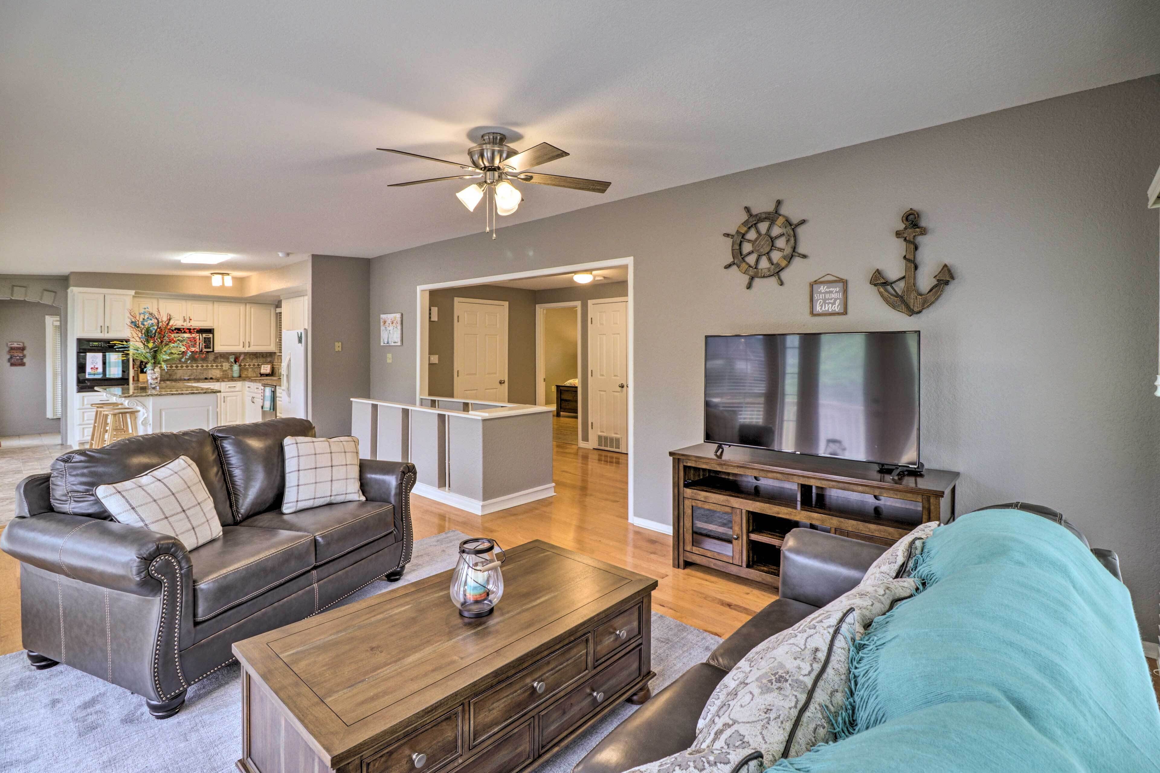 A living room with a sofa, coffee table, TV, and a ceiling fan.