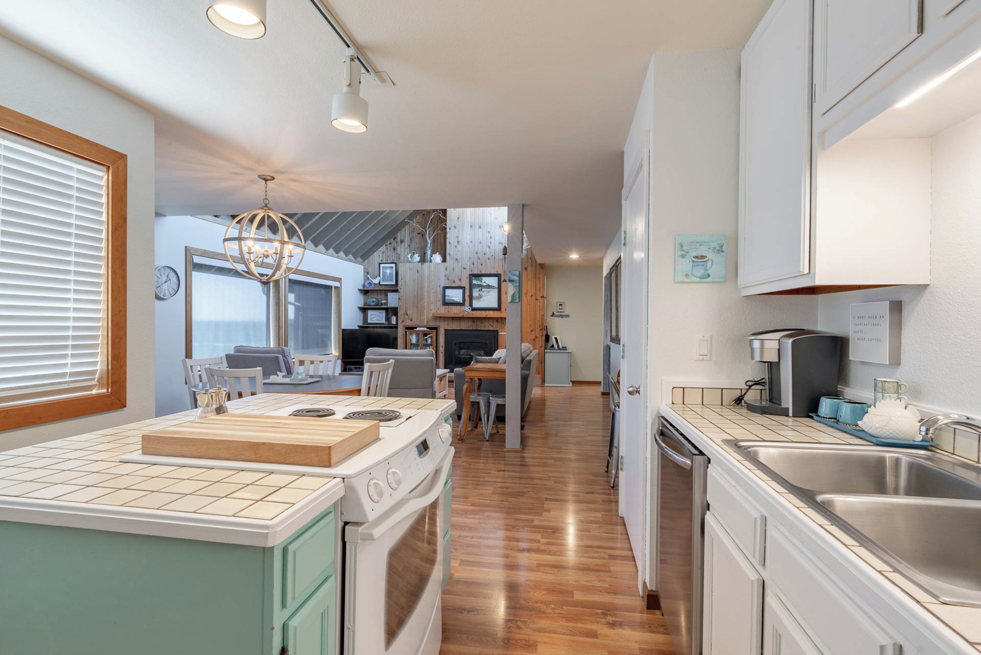 A modern kitchen with a central island, built-in appliances, and a dining area with a large window.