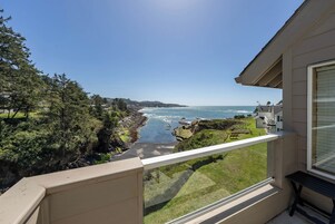 A balcony with a view of the ocean and coastal landscape.