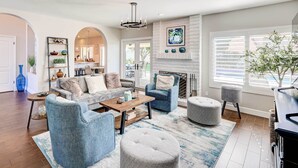 A spacious living room with a fireplace, comfortable seating, and a view of the outdoors.