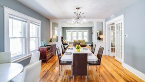A spacious dining area with a large table, chairs, and a chandelier. - Cozy Indiana Getaway Near Washington Park Zoo! (Michigan City)