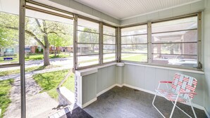 A corner room with large windows, a white ceiling, and a red and white striped chair. - Cozy Indiana Getaway Near Washington Park Zoo! (Michigan City)
