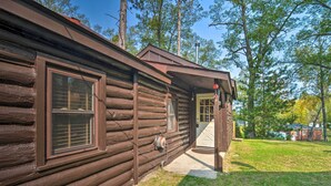 A rustic log cabin with a wooden porch and a window.