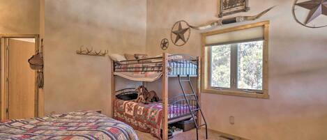 Un dormitorio con una cama litera, una cama grande, una ventana con vistas y una decoración de estrellas en la pared.