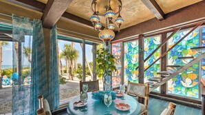A dining area with a round table, chairs, and a hanging light fixture. - Beachfront Home on Gulf of Mexico w/ Indoor Pool (Englewood)
