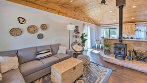 A cozy living room with a wooden ceiling, a sofa, a coffee table, and a fireplace. - 1 Mi to Hiking: Chic Show Low Escape w/ Fire Pit! (Show Low)