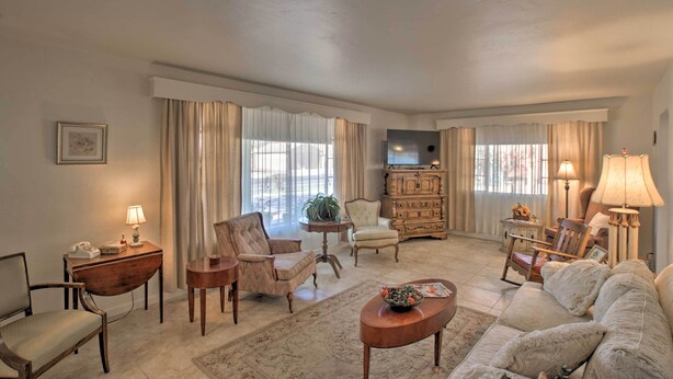 A spacious living room with a large sofa, two armchairs, a coffee table, a television, and a fireplace. - Central Phoenix Home < 3 Mi to Downtown! (Phoenix)