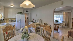 A kitchen with white cabinets, a dining table with chairs, and a hanging light fixture. - Central Phoenix Home < 3 Mi to Downtown! (Phoenix)