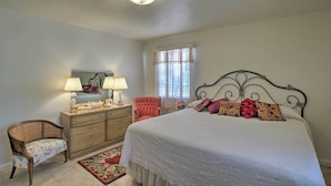 A bedroom with a bed, a dresser, a chair, a mirror, and a window with curtains. - Central Phoenix Home < 3 Mi to Downtown! (Phoenix)