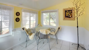Un coin repas comprenant une table ronde, quatre chaises et un lampadaire.