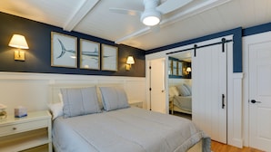 A bedroom with a bed, nightstands, a ceiling fan, and a wardrobe. - Avalon Vacation Rental w/ Porch & Grill! (Avalon)