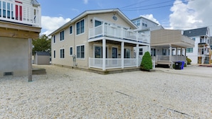 A beachfront property with a two-story house, a covered porch, and a small garden. - Avalon Vacation Rental w/ Porch & Grill! (Avalon)
