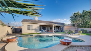 Ein Pool mit gewölbter Kante, eine Hängematte und ein Haus im Hintergrund.