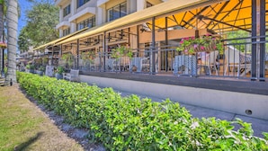 A hotel with outdoor seating, a covered patio, and a well-maintained garden. - Sleek Coastal Abode: 1 Block to Naples Beach! (Naples)