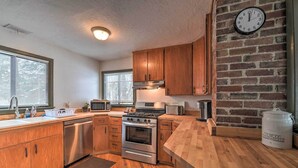 A kitchen with wooden cabinets, a stainless steel stove, a microwave, and a toaster. - Spacious Irwin Home on Snake River! (Irwin)