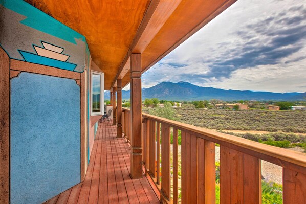A wooden deck with a view of mountains and sparse vegetation. - Taos Area Escape on 1.5 Acres: Panoramic Mtn Views (El Prado)
