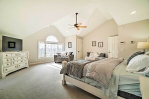 A bedroom with a bed, a dresser, a chair, a ceiling fan, and a window. - Relax Poolside! Family Getaway in Nashville Area (Pegram)