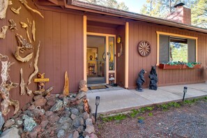 A wooden building with a welcoming sign, a stone wall, and bear statues. - Deck + Fireplace: Cozy Pinetop Lakes Cabin! (Pinetop)