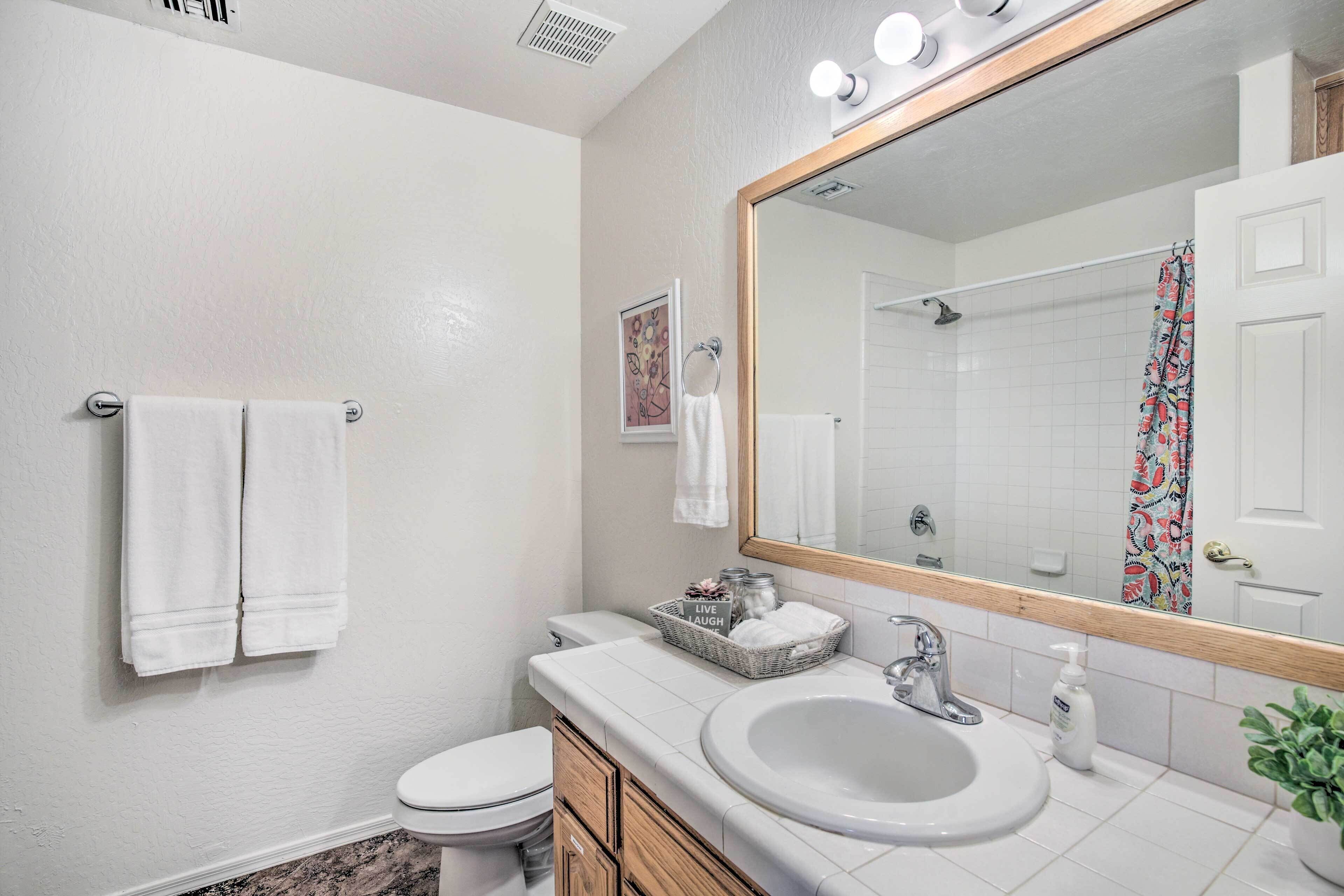 A bathroom with a white sink, a mirror, and a toilet.