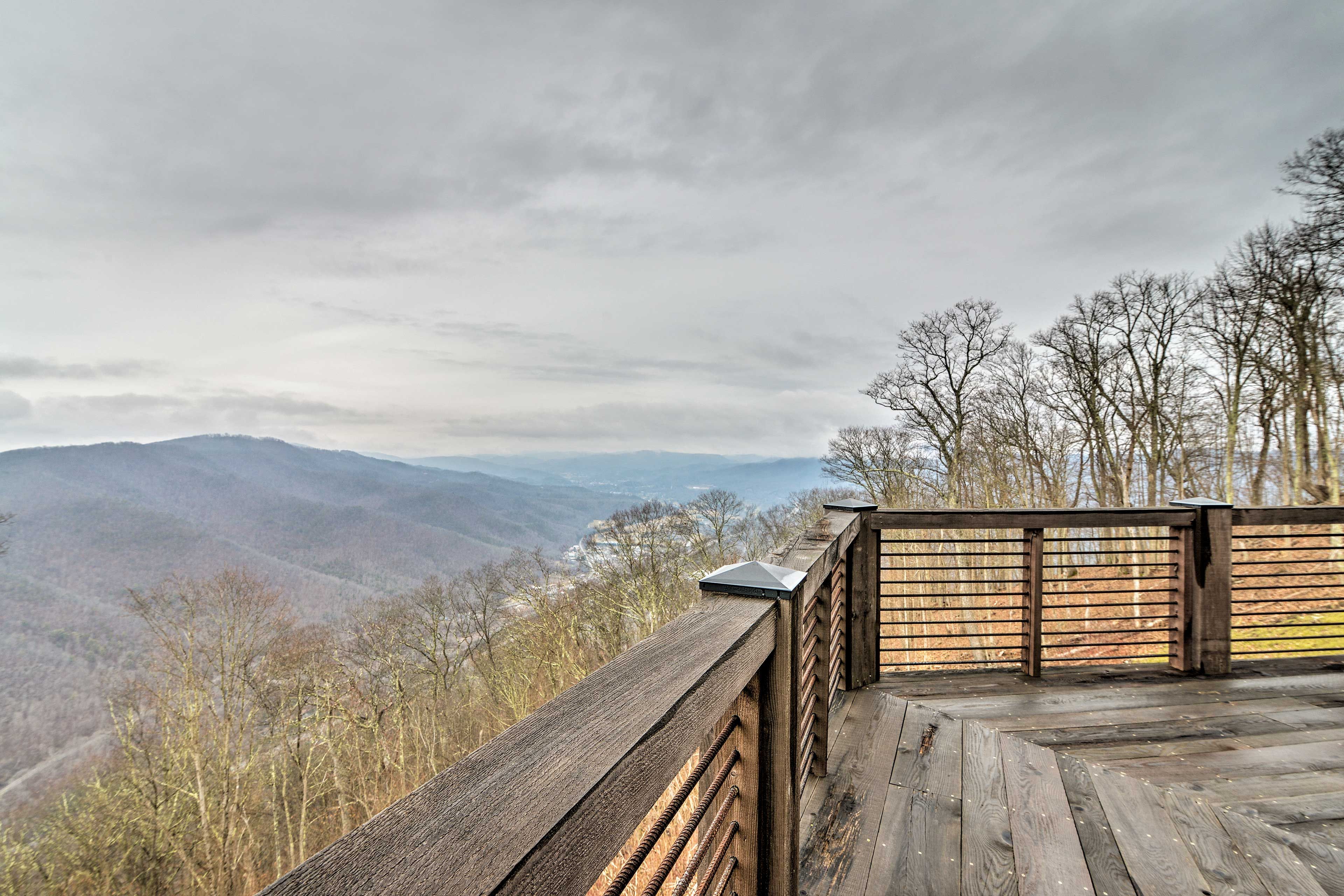 A wooden deck with a view of a mountainous landscape.