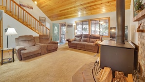 Ein gemütliches Wohnzimmer mit Holzbalkendecke, Kamin und zwei Sofas.