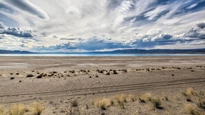 A vast, flat landscape with sparse vegetation and distant mountains under a cloudy sky. - Charming Paris House ~ 1 1/2 Mi to Canyon! (Paris)