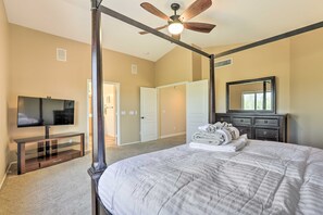 A bedroom with a four-poster bed, a television on a stand, a ceiling fan, and a mirror above a dresser. - Private Pool & Yard: Central Cave Creek Retreat! (Cave Creek)