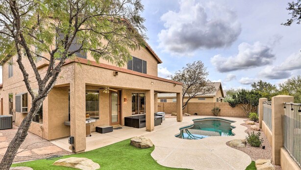 Uma casa moderna com piscina, pátio e uma árvore.