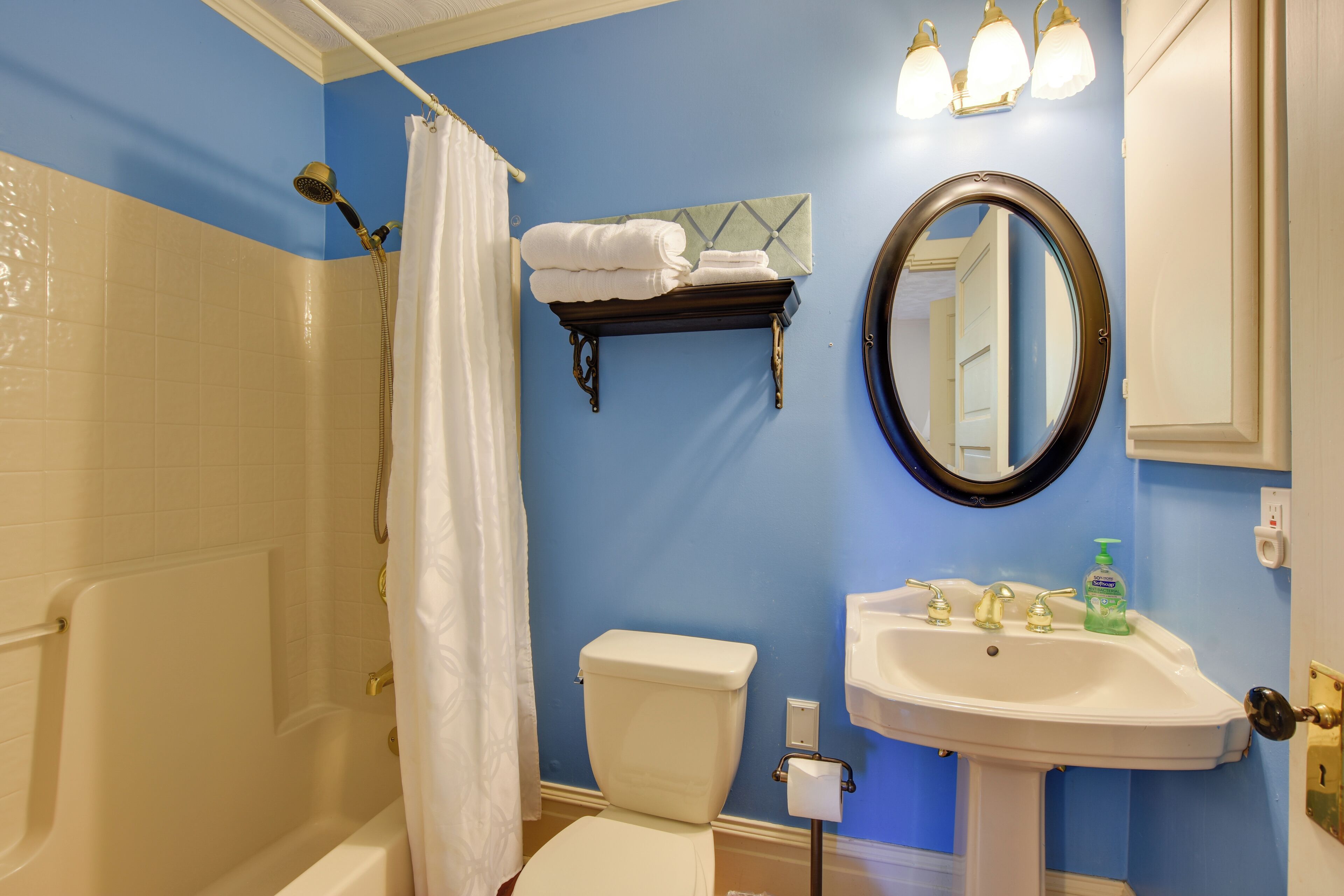 A bathroom with a bathtub, toilet, sink, and a shower curtain.