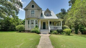 A two-story house with a wrap-around porch, a front entrance, and a small front yard. - Historic Hot Springs Home < 1 Mi to Oaklawn! (Hot Springs)