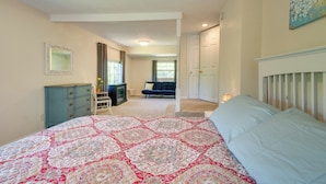 A bedroom with a large bed, a dresser, a television, and a sofa. - Fisherman-friendly Bull Shoals Escape on Lakefront (Bull Shoals)